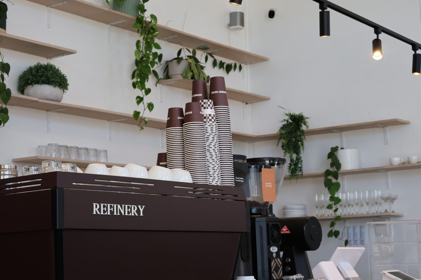 The Refinery espresso machine with stacked branded takeaway cups