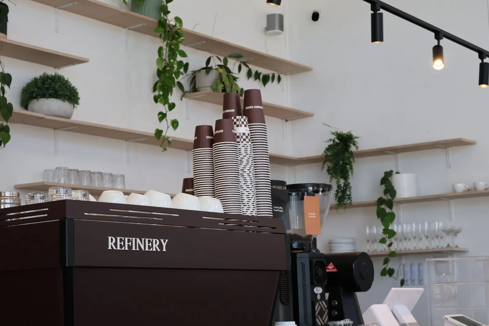The Refinery espresso machine with stacked branded takeaway cups