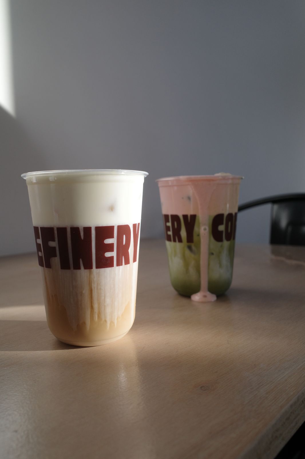 Two Refinery drinks side-lit on a cafe table