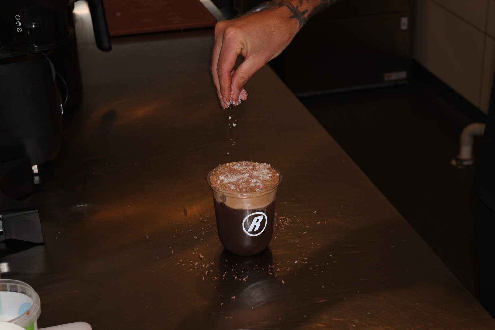 Coconut sprinkled over a Relaxed Espresso iced chocolate behind the bar