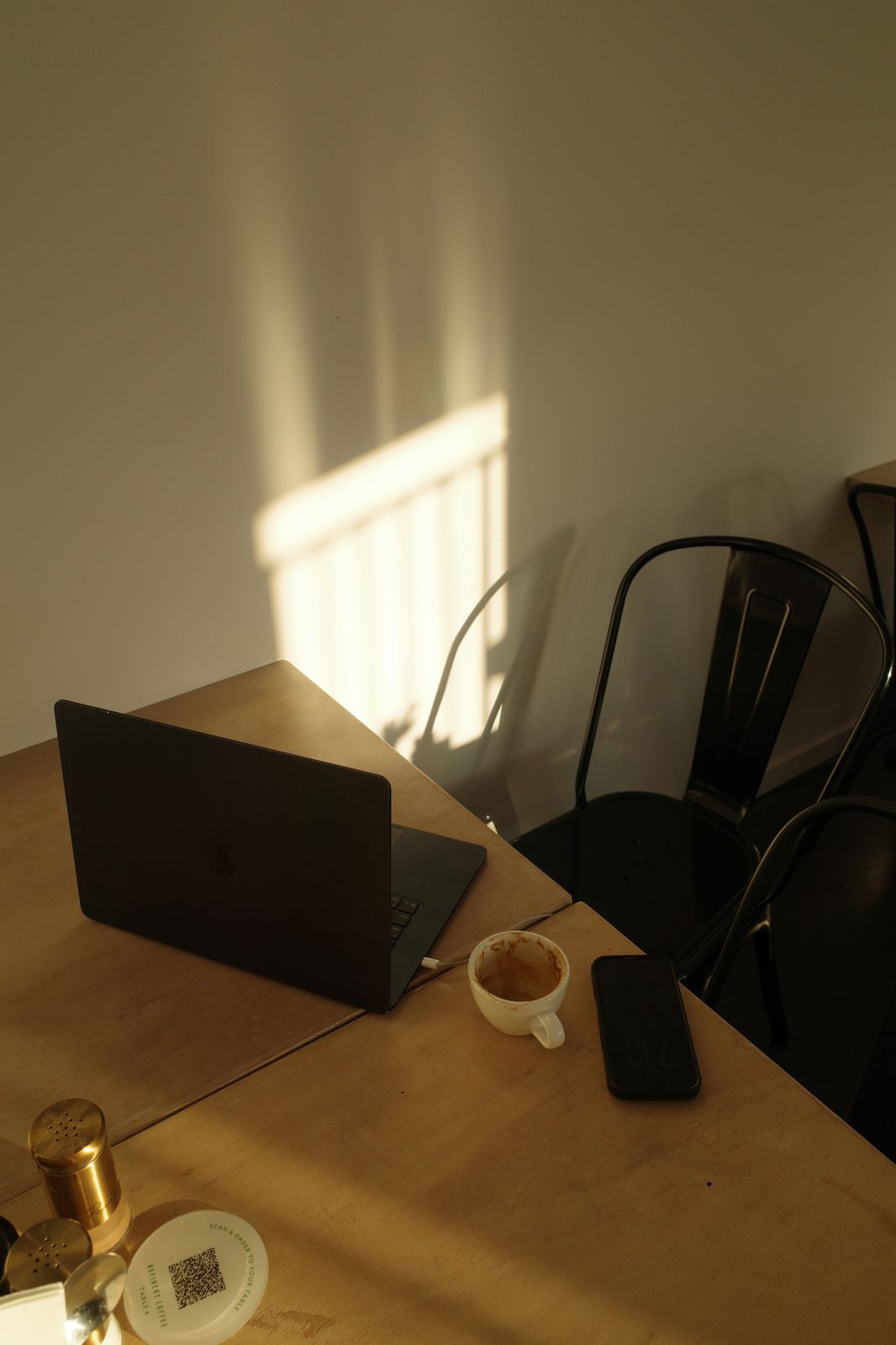The Suede Agency working from a partner cafe — laptop and flat white in the morning light